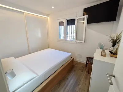 a small bedroom with a white bed and a window at Modern Beach Front Home by Chiclana Dreams in Chiclana de la Frontera