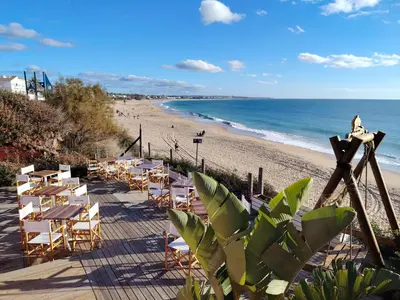 a sunset over a body of water with a lighthouse at Modern Beach Front Home by Chiclana Dreams in Chiclana de la Frontera