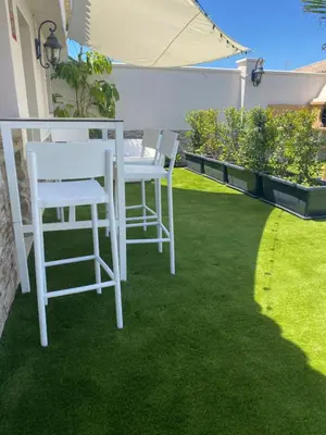 two white chairs and a table on a lawn at Musa del Paraíso in Novo Sancti Petri