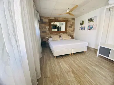 a bedroom with a white bed and a mirror at Musa del Paraíso in Novo Sancti Petri
