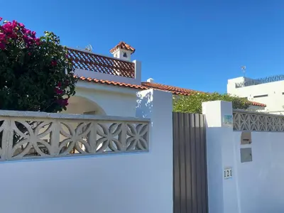 a white house with a fence and a flower box at Casitasmanoli Fuente del Gallo in Conil de la Frontera