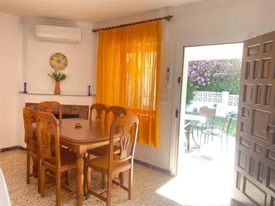 a dining room with a wooden table and chairs at Casitasmanoli Fuente del Gallo in Conil de la Frontera