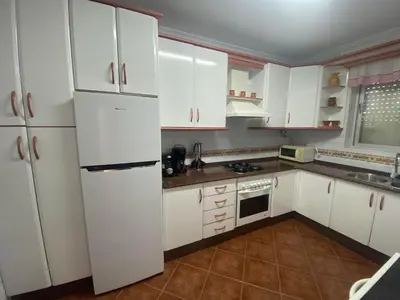 a kitchen with white cabinets and a white refrigerator at Casitasmanoli Fuente del Gallo in Conil de la Frontera