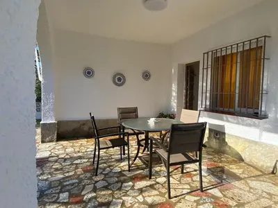 a dining room with a table and chairs on a patio at Casitasmanoli Fuente del Gallo in Conil de la Frontera