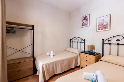 a bedroom with two twin beds and a dresser at Apartamento Isaac Peral 1 in Chipiona