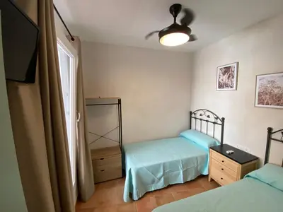 a bedroom with two twin beds and a window at Apartamento Isaac Peral 1 in Chipiona