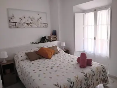 a bedroom with a bed with a teddy bear on it at Apartamento con encanto en el corazón de la ciudad in Jerez de la Frontera
