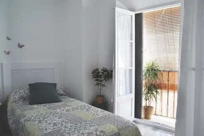 a bedroom with a bed and a window at Apartamento con encanto en el corazón de la ciudad in Jerez de la Frontera