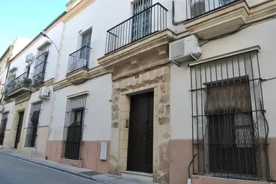 a building with balconies and a door on a street at Apartamento con encanto en el corazón de la ciudad in Jerez de la Frontera
