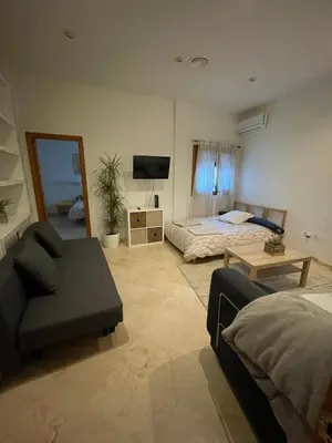 a living room with a bed and a couch at Apartamento Céntrico in El Puerto de Santa María