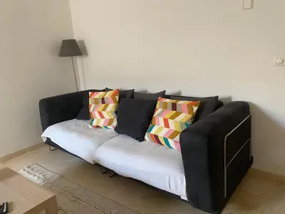 a black couch with colorful pillows in a living room at Apartamento Céntrico in El Puerto de Santa María
