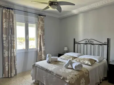 a bedroom with a bed with a ceiling fan at Apartamento El Faro - Ole Solutions in El Puerto de Santa María