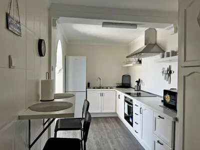 a kitchen with white cabinets and a white refrigerator at Apartamento El Faro - Ole Solutions in El Puerto de Santa María