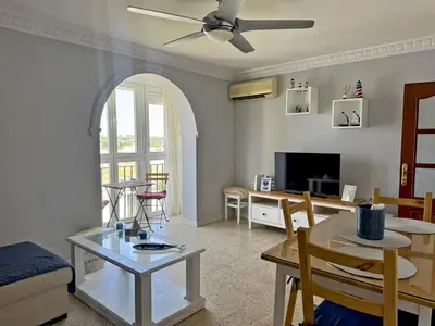 a living room with a table and a dining room at Apartamento El Faro - Ole Solutions in El Puerto de Santa María