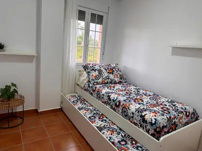 a small room with a bed and a window at Mika's House Valley in Sanlúcar de Barrameda