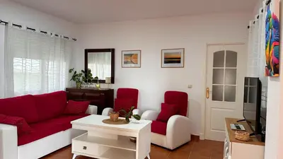 a living room with a red couch and red chairs at Mika's House Valley in Sanlúcar de Barrameda