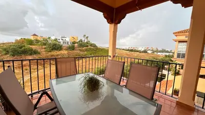 a glass table and chairs on a balcony at Mika's House Valley in Sanlúcar de Barrameda