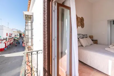 a balcony with a bed and a view of a street at Apartamento Isaac Peral 3 in Chipiona
