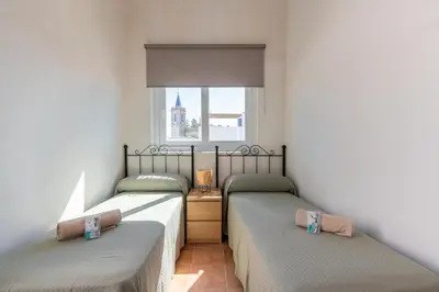 two twin beds in a room with a window at Apartamento Isaac Peral 3 in Chipiona