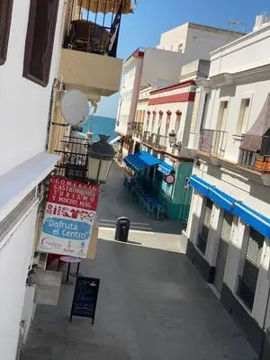 an empty street with buildings and the ocean in the background at Apartamento Isaac Peral 3 in Chipiona