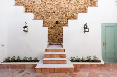 a hallway with stairs and a green door at Apartamento Isaac Peral 3 in Chipiona