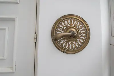 a bronze door knocker on a white door at Montera Suite Cádiz in Cádiz