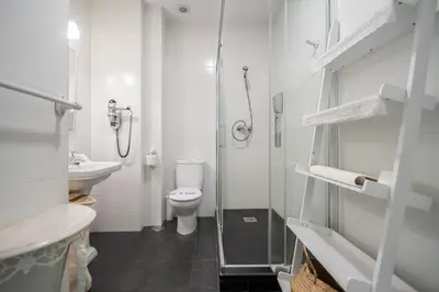 a bathroom with a shower and a toilet and a sink at Montera Suite Cádiz in Cádiz