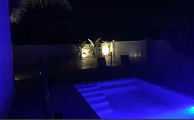 a swimming pool at night with blue lights at Chalet con encanto en Conil SOLO FAMILIAS Y PAREJAS in Conil de la Frontera