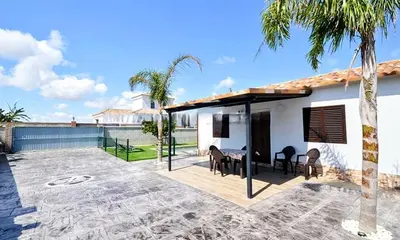 a patio with a table and chairs and a house at Chalet con encanto en Conil SOLO FAMILIAS Y PAREJAS in Conil de la Frontera