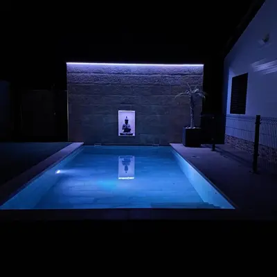 a swimming pool with blue lighting in a dark room at Chalet con encanto en Conil SOLO FAMILIAS Y PAREJAS in Conil de la Frontera