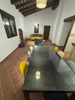 a room with a table and chairs and a couch at Villa Los abuelos in Hozanejos