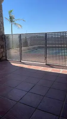 a wooden fence with a palm tree in the background at Villa Los abuelos in Hozanejos