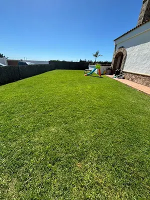 a large yard with green grass and a building at Villa Los abuelos in Hozanejos