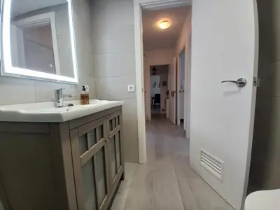 a bathroom with a sink and a mirror and a hallway at Vistahermosa-El ancla in El Puerto de Santa María