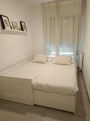a white bed in a white room with a window at Vistahermosa-El ancla in El Puerto de Santa María