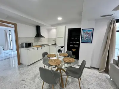 a kitchen with a table and chairs in a room at Lindo Pisito Sanlucar Calle Ancha in Sanlúcar de Barrameda