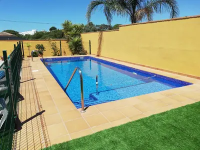 a swimming pool in a yard next to a fence at Chalet Casa Paqui solo familias o parejas in Conil de la Frontera