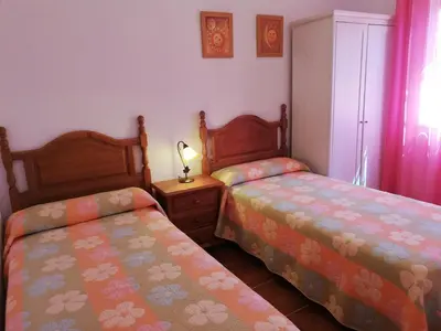 a bedroom with two beds and a lamp on a table at Chalet Casa Paqui solo familias o parejas in Conil de la Frontera