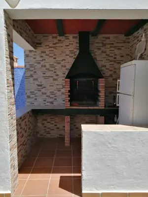 a kitchen with a brick wall and a stove at Chalet Casa Paqui solo familias o parejas in Conil de la Frontera