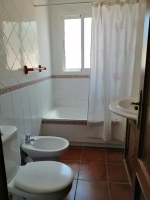 a bathroom with a toilet and a tub and a sink at Chalet Casa Paqui solo familias o parejas in Conil de la Frontera