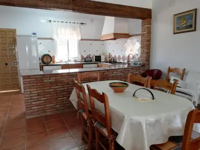 a kitchen with a table with a white table cloth at Chalet Casa Paqui solo familias o parejas in Conil de la Frontera