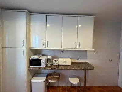 a kitchen with white cabinets and a counter with a microwave at Villa Rocio in El Puerto de Santa María