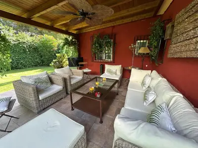 a patio with white couches and a table at Villa Rocio in El Puerto de Santa María