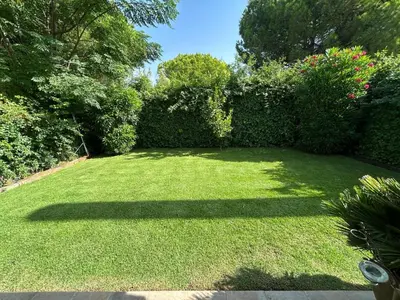 a garden with a large lawn with trees and bushes at Villa Rocio in El Puerto de Santa María