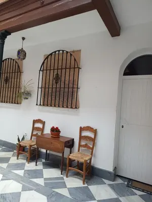 a patio with two chairs and a table and a bird cage at Vicario 11 Estudio in El Puerto de Santa María