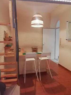 a kitchen with two white chairs and a table at Vicario 11 Estudio in El Puerto de Santa María