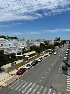 a city street with cars parked on the road at Apartamento Valdés in El Puerto de Santa María