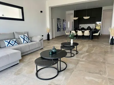 a living room with two tables and a couch at Poniente Beach House in Chiclana de la Frontera