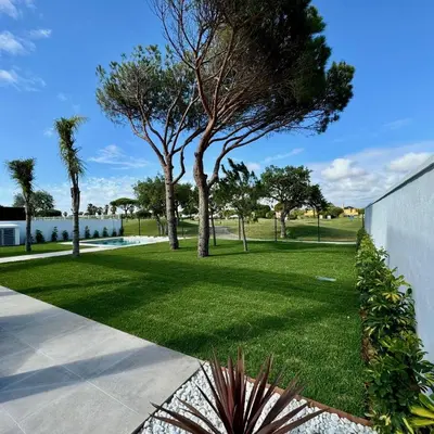 a park with trees and grass and a building at Poniente Beach House in Chiclana de la Frontera