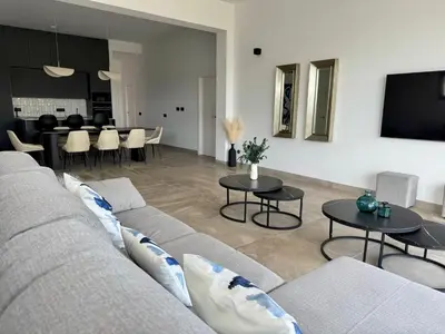 a living room with a couch and tables and a tv at Poniente Beach House in Chiclana de la Frontera